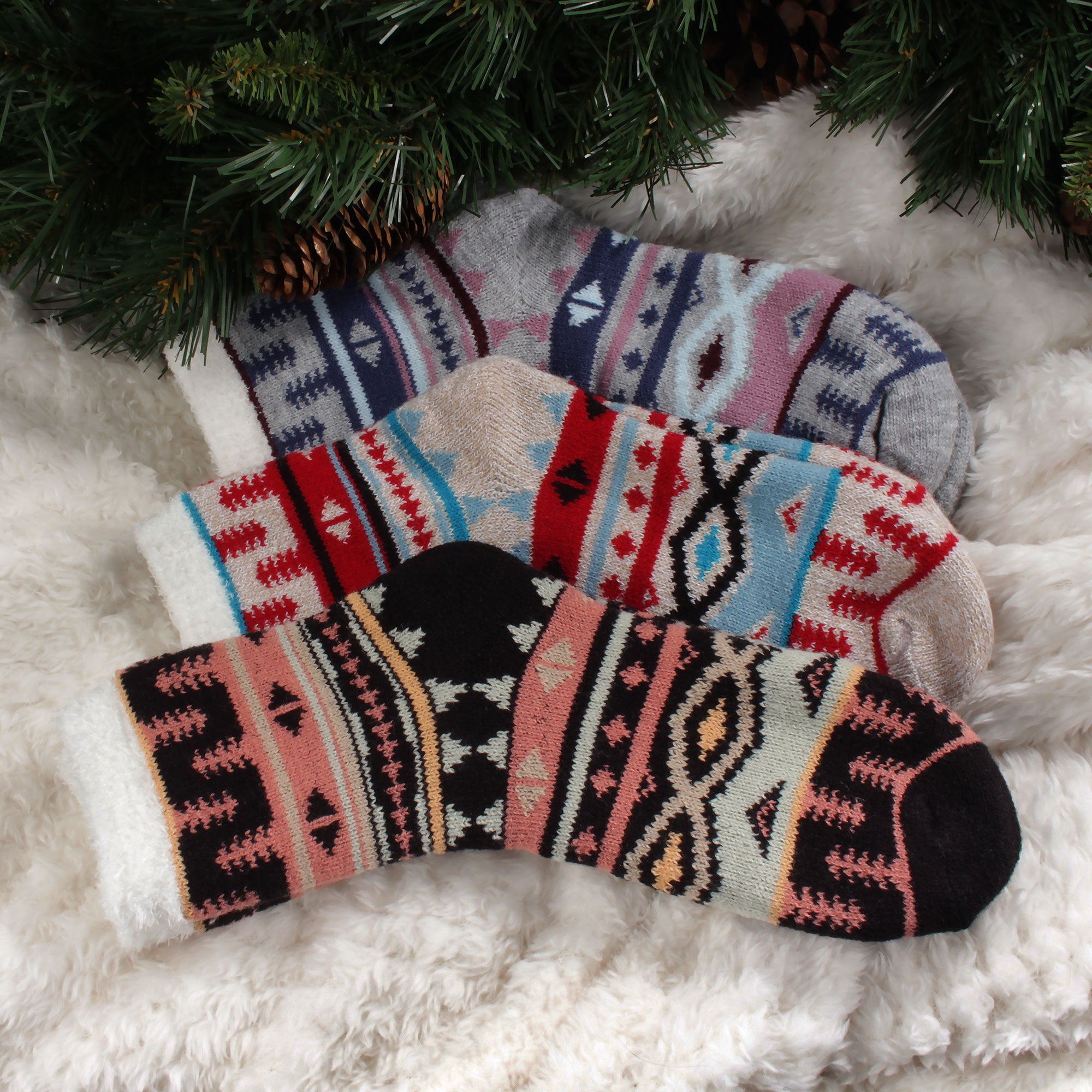 3 socks of the same pattern but different color laying on blanket