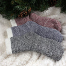 3 socks of the same pattern but different color laying on blanket