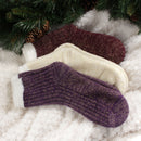 3 socks of the same pattern but different color laying on blanket