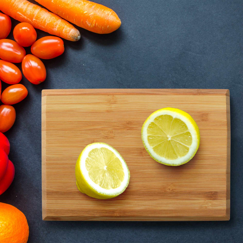 bamboo cutting board with chamfered edge lifestyle image lemon carrots and tomatos