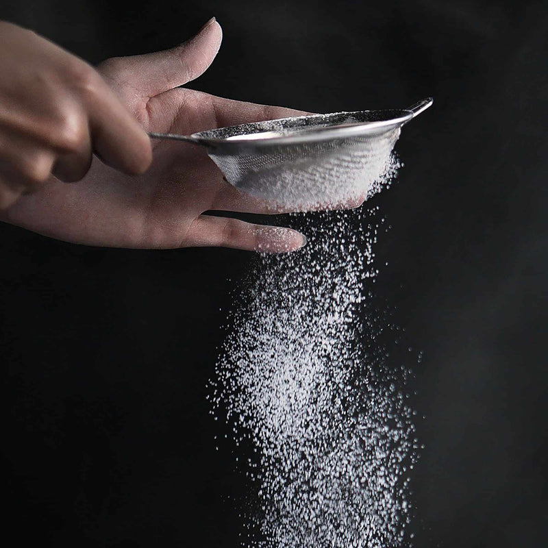 sifting salt with a strainer