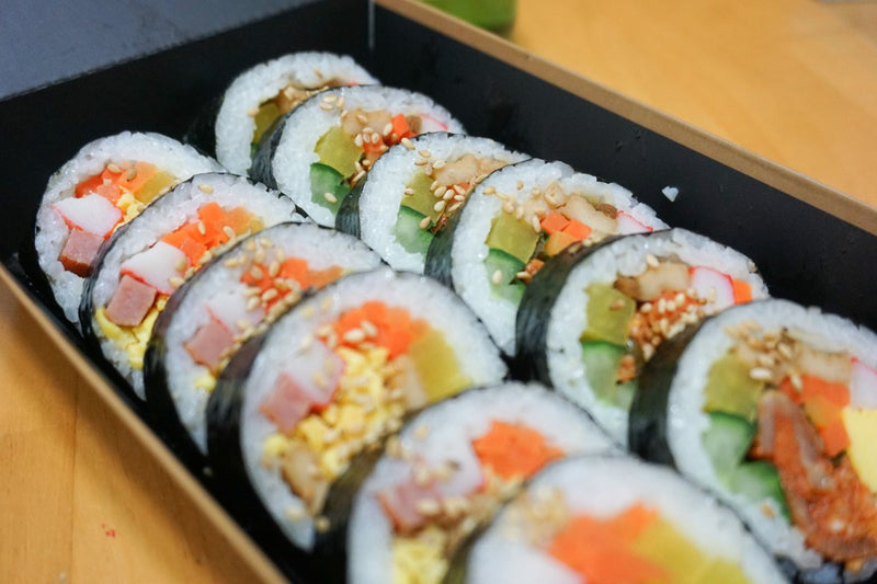 sushi piled together in two lines on serving tray