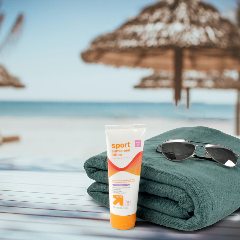 Towel sunscreen and glasses at beach