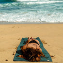 Person laying on towel at beach